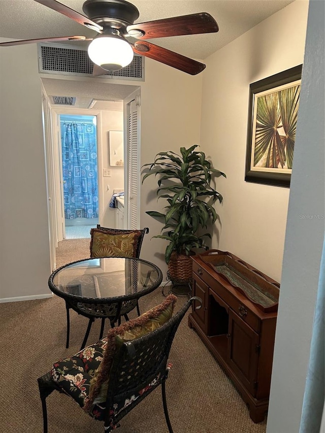 dining area with a textured ceiling, carpet floors, and ceiling fan