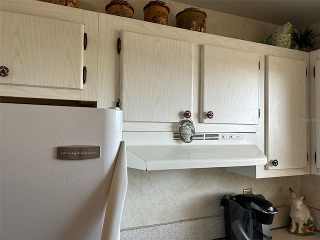 interior details featuring under cabinet range hood and light brown cabinetry