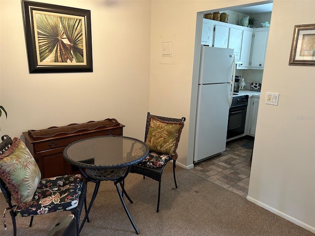 dining area with baseboards and dark colored carpet