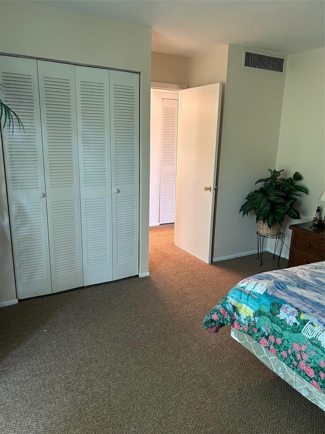 carpeted bedroom with a closet, visible vents, and baseboards