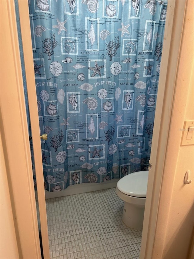 bathroom with toilet and tile patterned floors