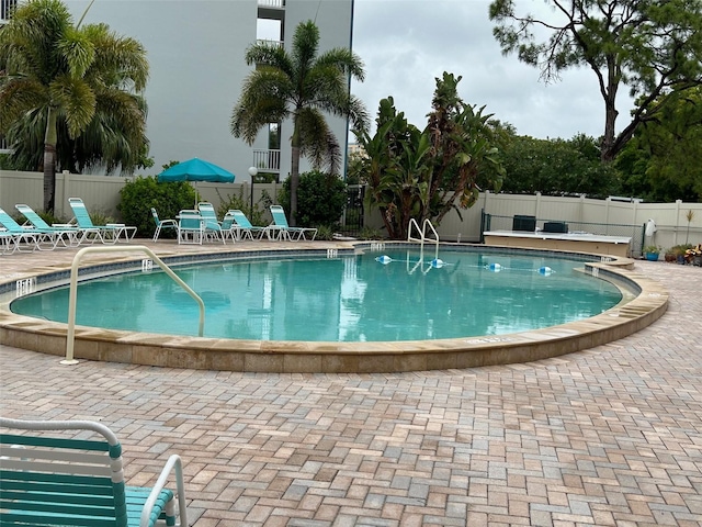 pool with fence and a patio