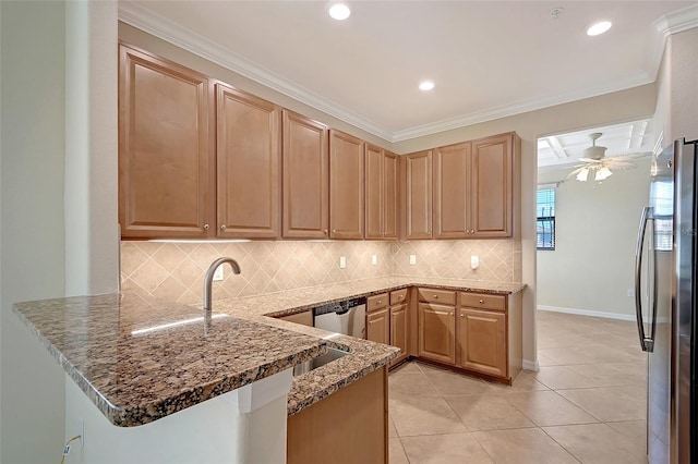 kitchen featuring dark stone counters, crown molding, ceiling fan, appliances with stainless steel finishes, and kitchen peninsula