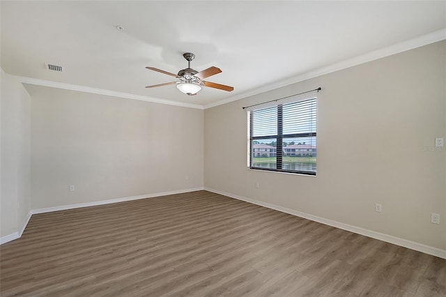 empty room featuring ceiling fan, wood-type flooring, and ornamental molding