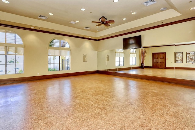 interior space featuring a tray ceiling, a wealth of natural light, and ceiling fan