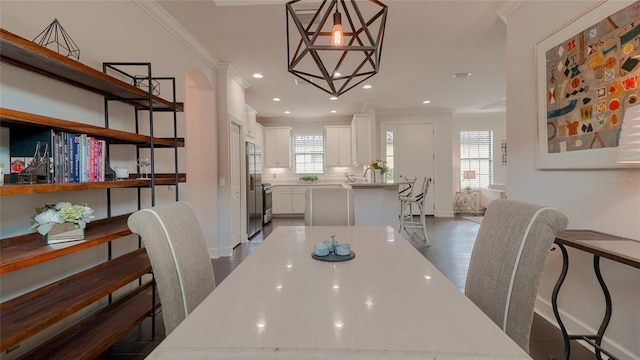 dining space featuring plenty of natural light, dark hardwood / wood-style flooring, and crown molding