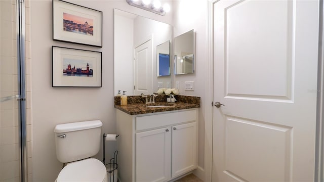 bathroom with walk in shower, vanity, and toilet