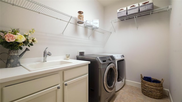 laundry room with washer and clothes dryer, cabinets, and sink