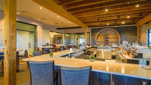 bar featuring beamed ceiling and hardwood / wood-style flooring