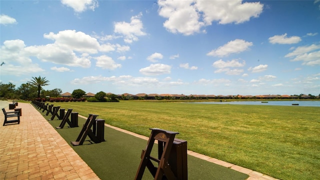 surrounding community with a lawn and a water view