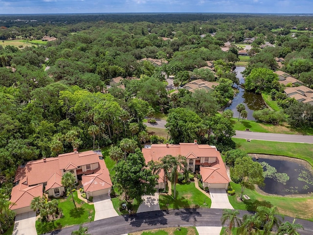 aerial view featuring a forest view and a water view