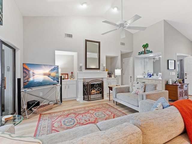 living room with ceiling fan, light hardwood / wood-style flooring, and high vaulted ceiling