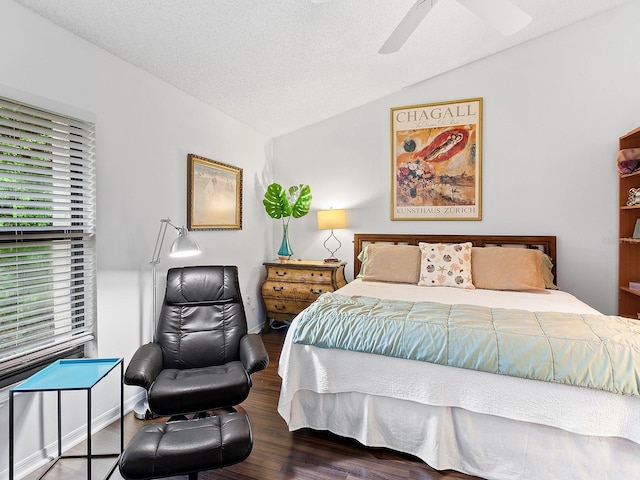 bedroom with ceiling fan, dark wood-type flooring, a textured ceiling, and lofted ceiling