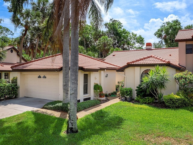 mediterranean / spanish-style house featuring a chimney, stucco siding, an attached garage, a front yard, and a tiled roof