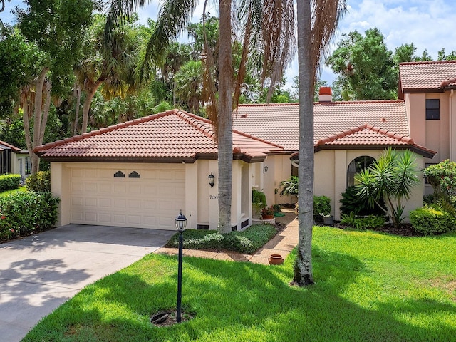 mediterranean / spanish-style home featuring a front yard and a garage