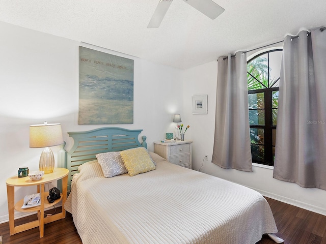 bedroom with dark wood-style floors, ceiling fan, a textured ceiling, and baseboards