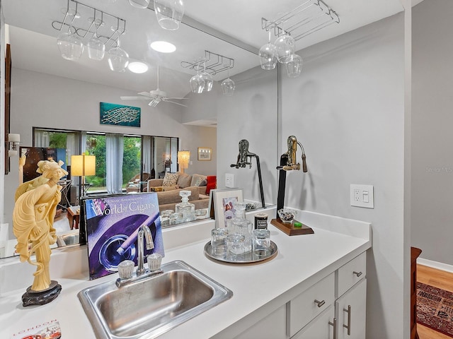 kitchen featuring ceiling fan, white cabinets, and sink