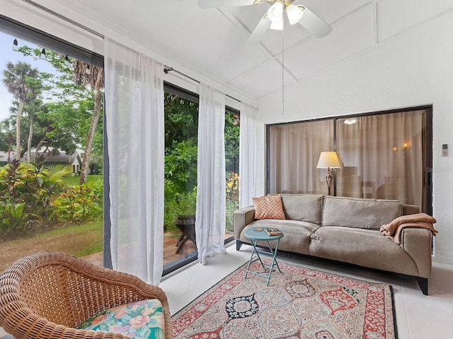 tiled living area with ceiling fan and lofted ceiling
