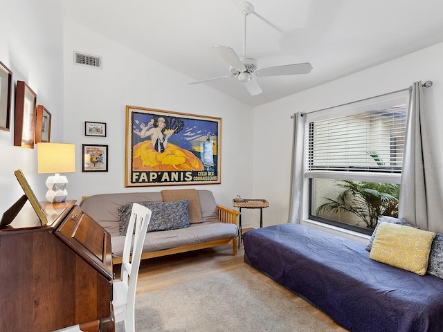 living room with ceiling fan, vaulted ceiling, wood finished floors, and visible vents