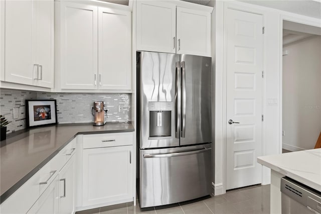 kitchen with appliances with stainless steel finishes, white cabinets, and light tile patterned floors