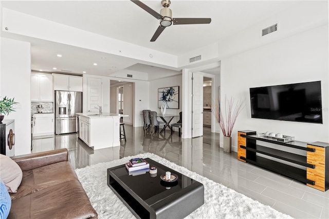 living room with ceiling fan and sink