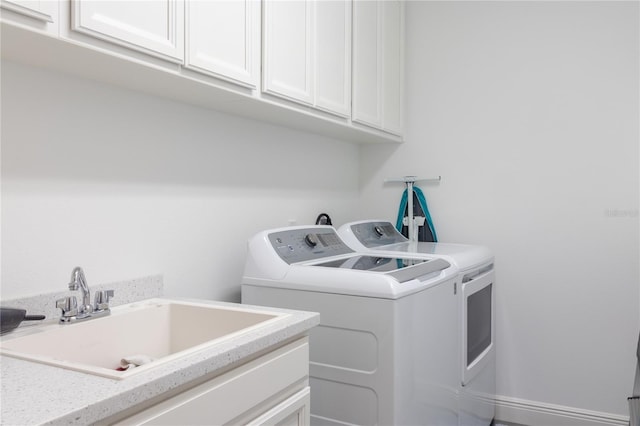 laundry room featuring sink, cabinets, and independent washer and dryer