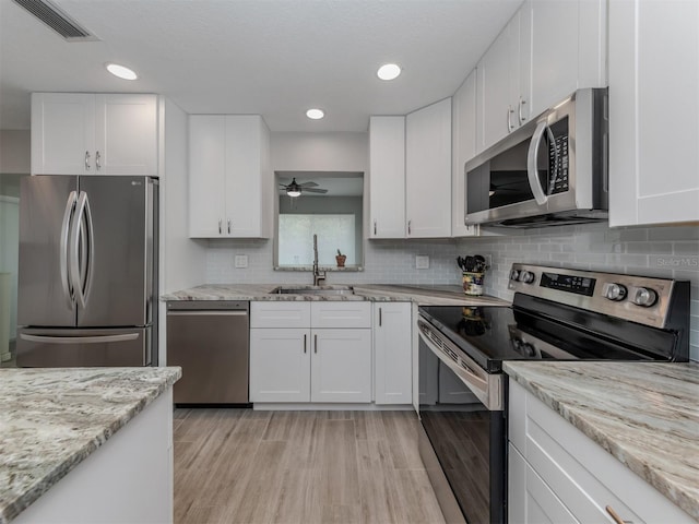 kitchen with ceiling fan, sink, white cabinets, and appliances with stainless steel finishes