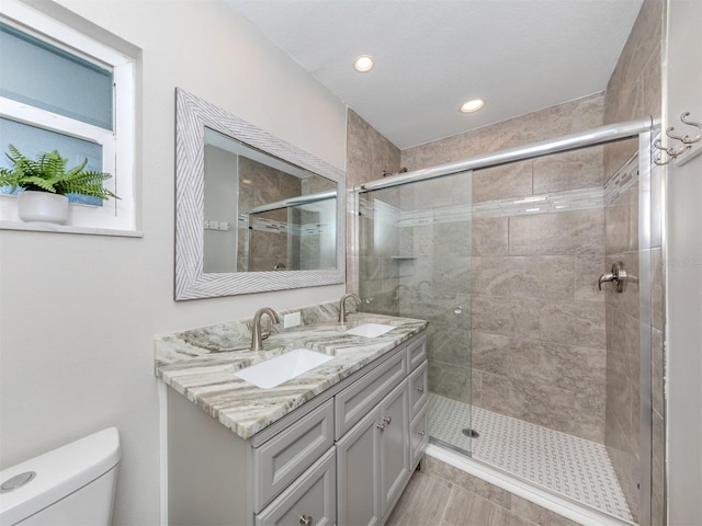 bathroom with vanity, toilet, and a shower with shower door