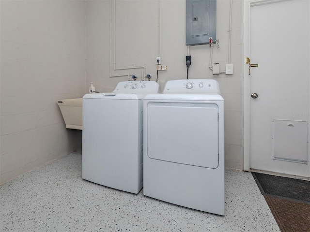 clothes washing area featuring electric panel and washer and clothes dryer