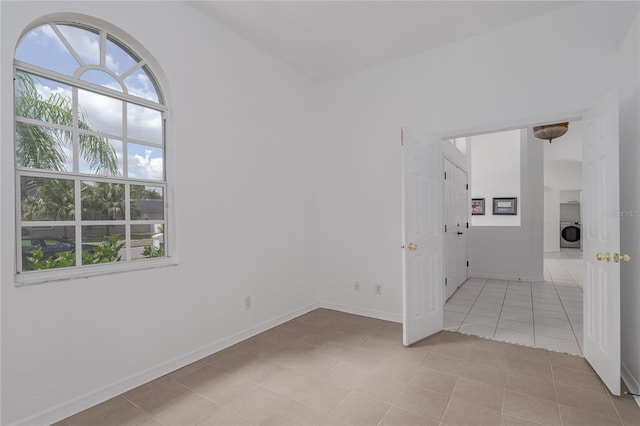 spare room with washer / dryer and light tile patterned floors