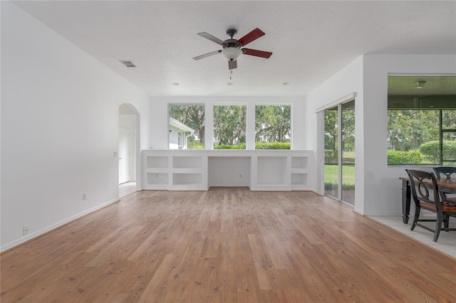 unfurnished living room featuring ceiling fan, a textured ceiling, and light hardwood / wood-style flooring