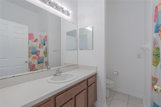 bathroom featuring tile patterned flooring, vanity, and toilet