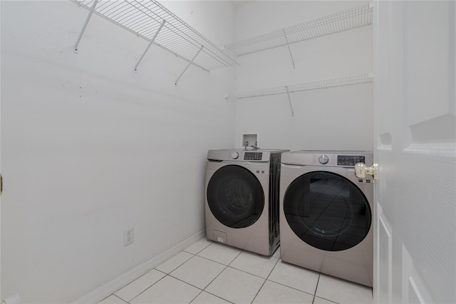 laundry room with washing machine and dryer and light tile patterned flooring