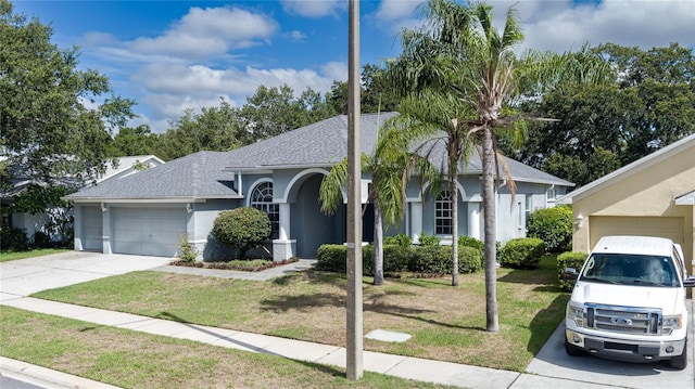 view of front of property with a front yard and a garage