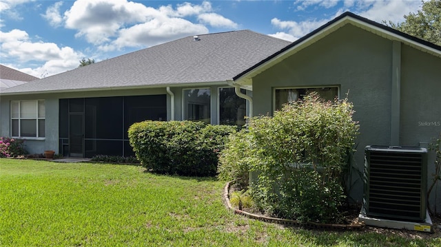 back of house featuring a yard, a sunroom, and central air condition unit