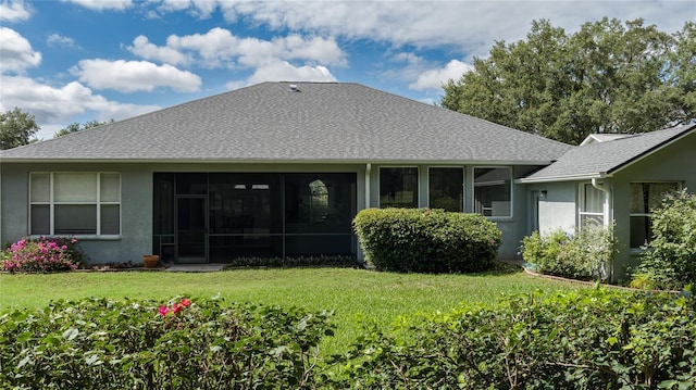 back of property featuring a sunroom and a lawn