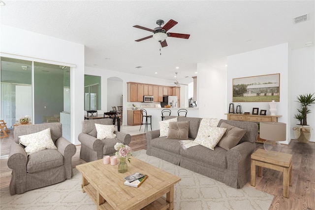 living room featuring ceiling fan and light wood-type flooring