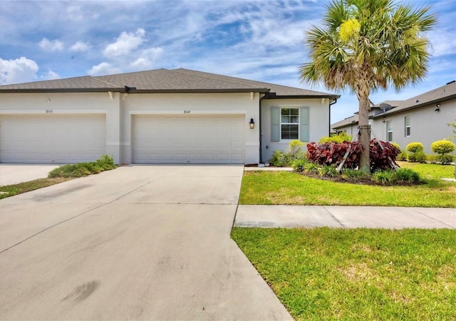 view of front of house with stucco siding, driveway, a front lawn, and a garage