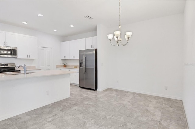 kitchen featuring an inviting chandelier, sink, hanging light fixtures, white cabinetry, and stainless steel appliances