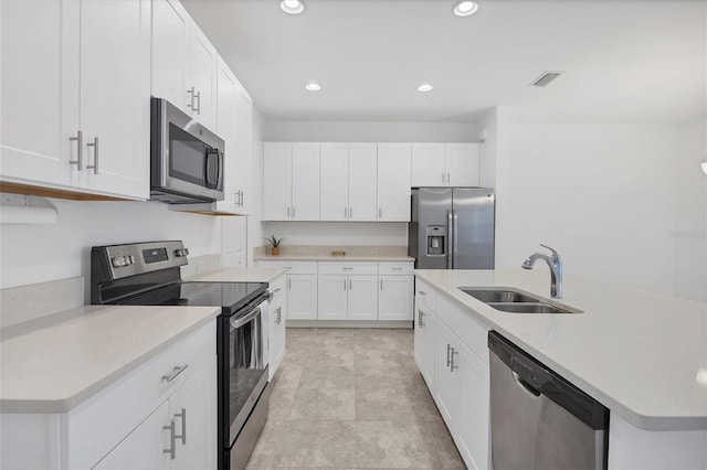 kitchen featuring white cabinetry, sink, a center island with sink, and appliances with stainless steel finishes