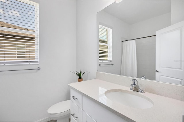 bathroom featuring curtained shower, vanity, and toilet