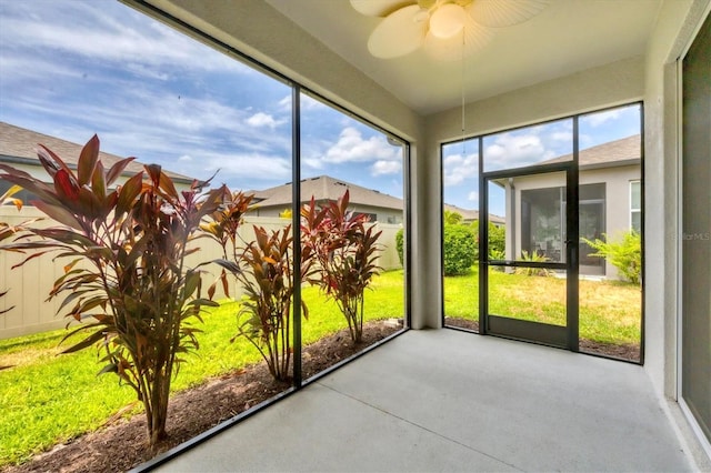 unfurnished sunroom with ceiling fan