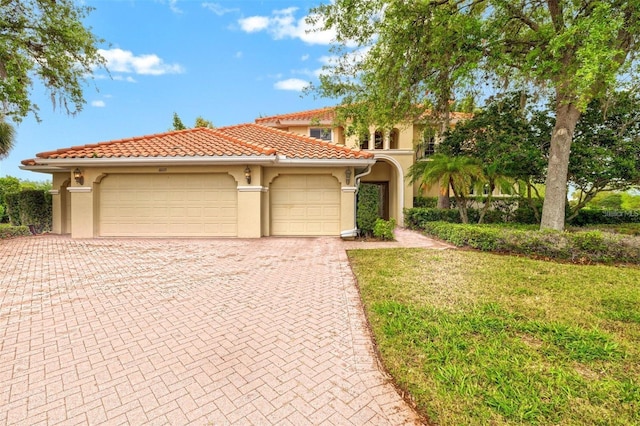 mediterranean / spanish-style home with a garage, a tile roof, decorative driveway, and stucco siding