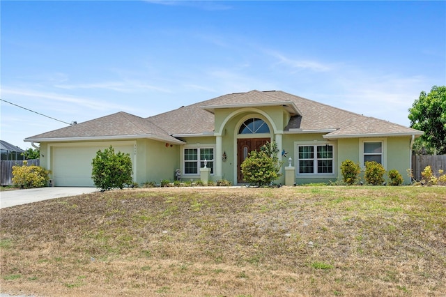 ranch-style house with a garage and a front lawn