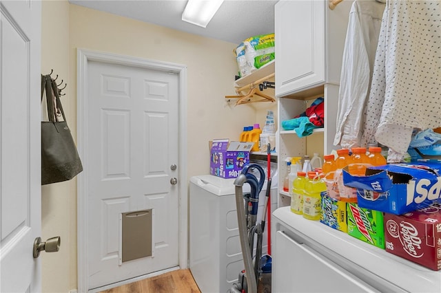 laundry room featuring hardwood / wood-style floors, cabinets, and independent washer and dryer