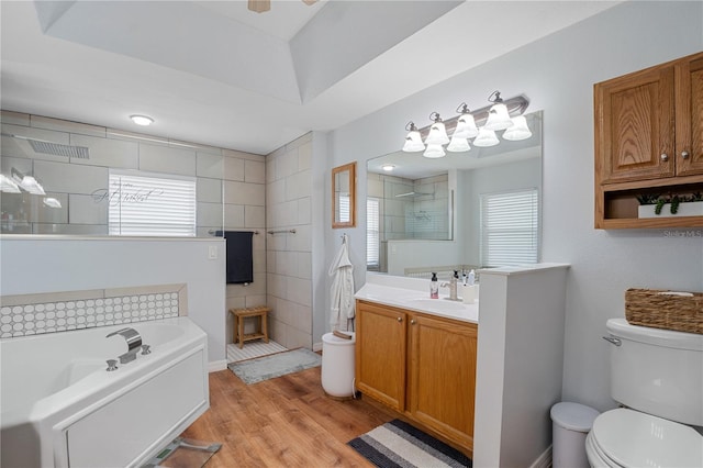 full bathroom with hardwood / wood-style floors, vanity, shower with separate bathtub, and toilet