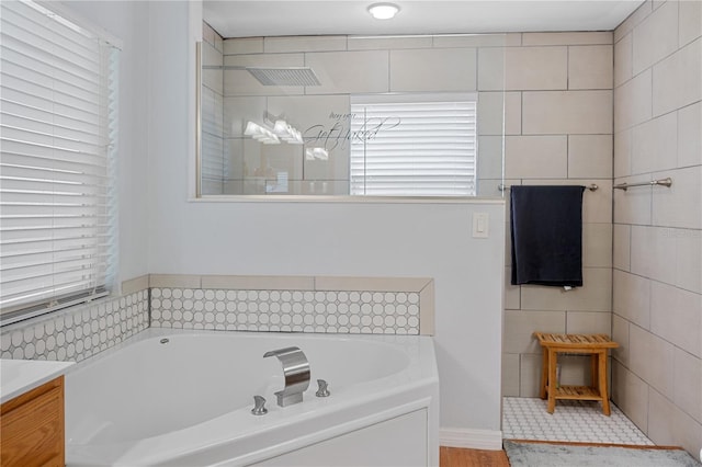 bathroom with vanity and shower with separate bathtub