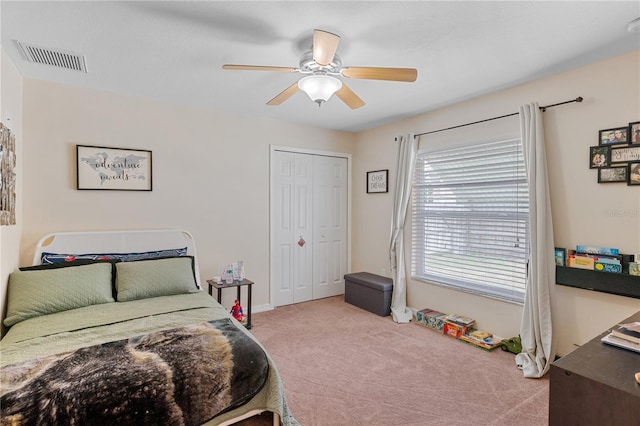 bedroom featuring ceiling fan, light carpet, and a closet