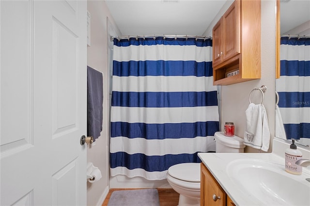 bathroom with a shower with curtain, vanity, toilet, and hardwood / wood-style flooring