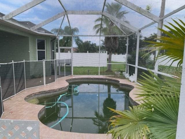 view of pool with a patio area and glass enclosure